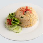 Riz sauté aux œufs, délicatement décoré dans l'assiette blanche
